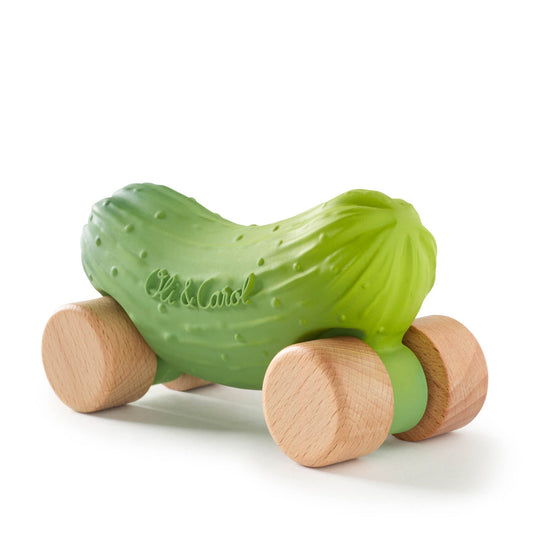 Green toy cucumber with wooden wheels on a white background