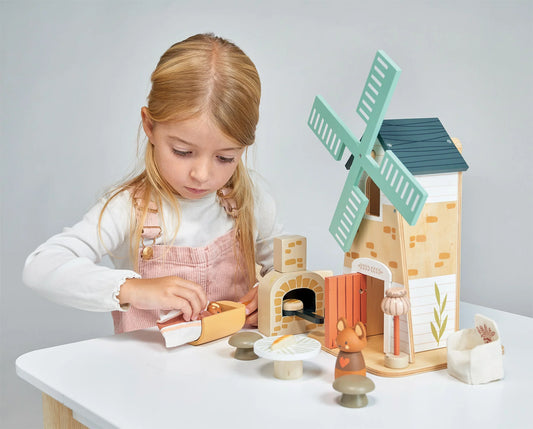 Child playing with a wooden toy set on a table