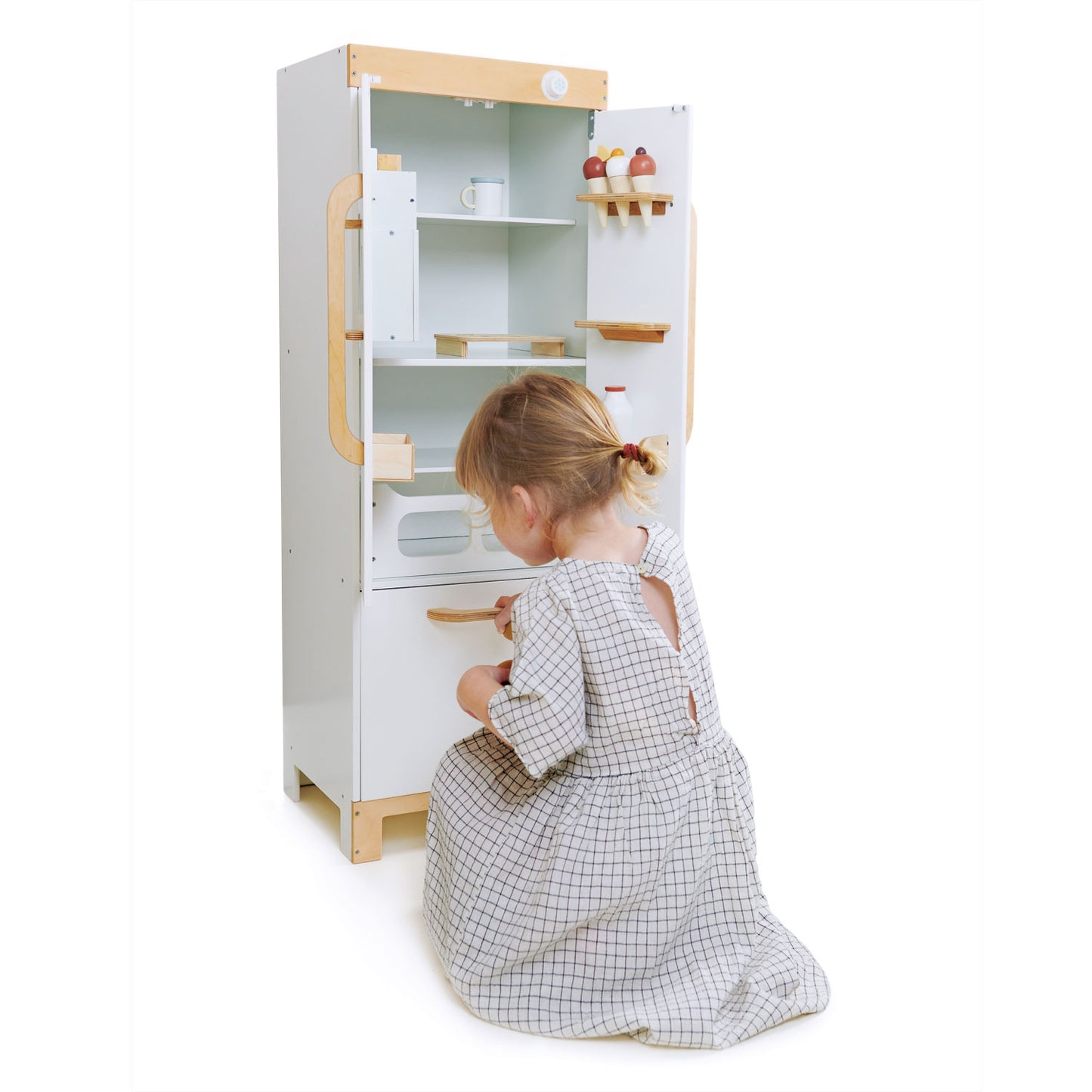 Child playing with a toy kitchen set on a white background