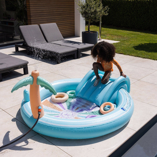 Child playing outdoors with wooden garden toys in summer