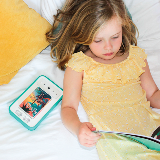 Young girl listening to a Voxblock audio player — screen-free storytelling toy for children starting school