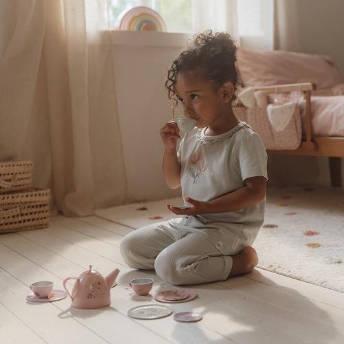 Child playing with a tea set in a softly lit room. Little Dutch Fairy Garden Tea Set