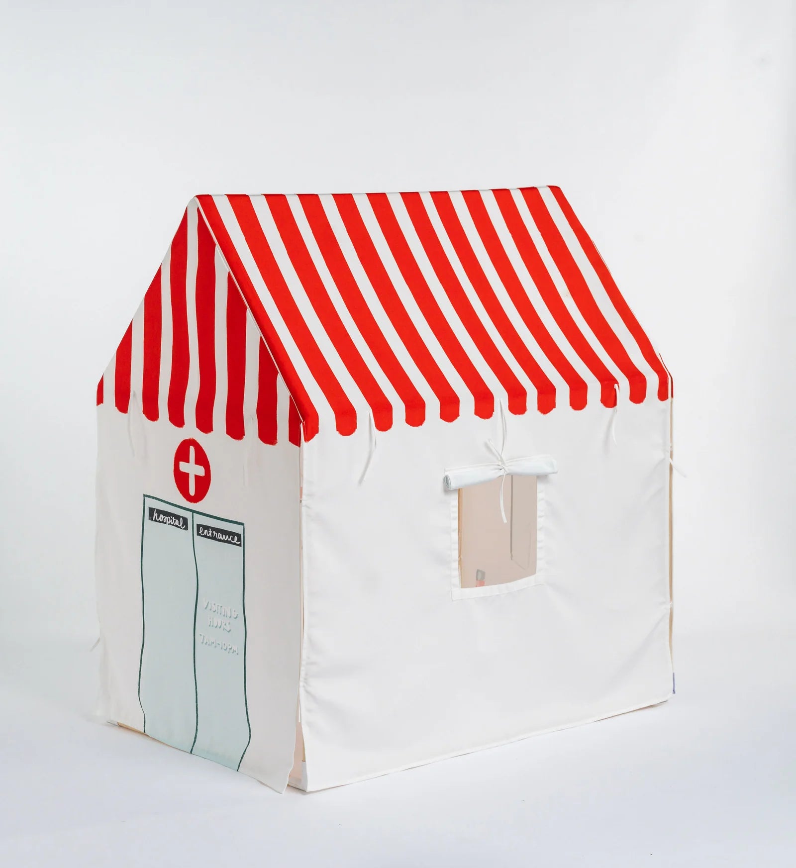 A children's play tent styled like a pharmacy, featuring a red and white striped roof and a white body with a window cutout and printed pharmacy-style graphics.