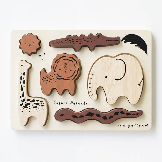 A wooden tray puzzle with six pieces shaped like safari animals, including a giraffe, lion, elephant, crocodile, and a snake, with a puzzle board featuring an illustration of a giraffe.