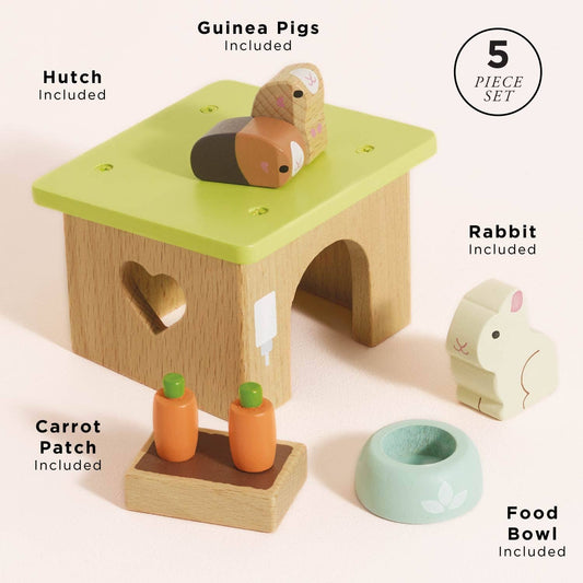 Wooden pet play set with guinea pig hutch, rabbit, carrots, and food bowl on a light background