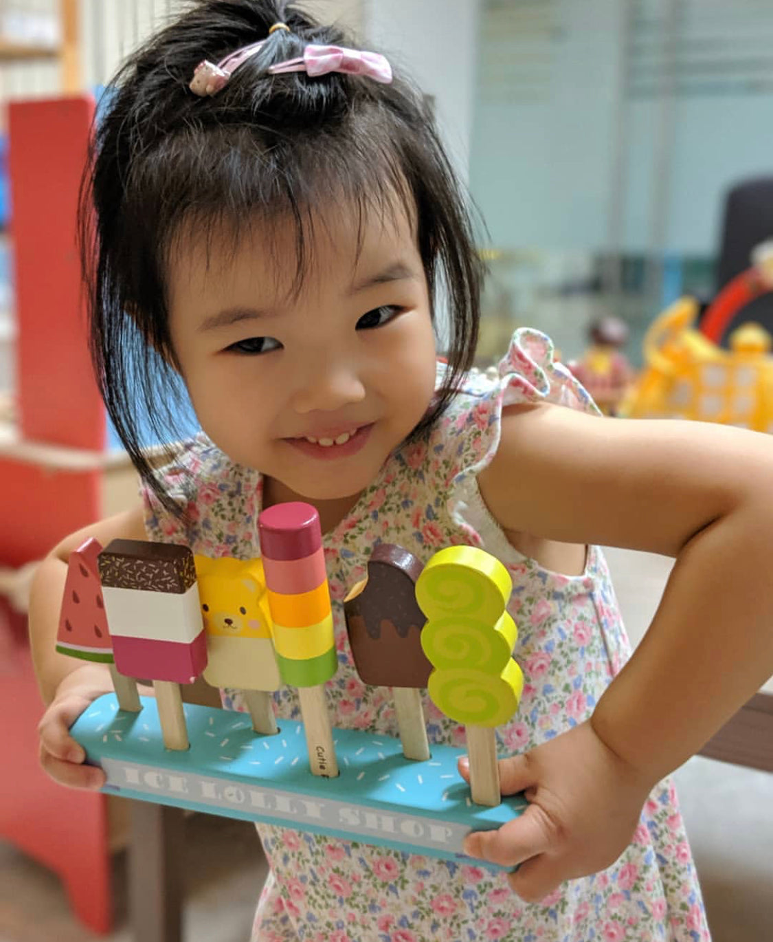 Child holding a tray with colorful ice cream cone toys