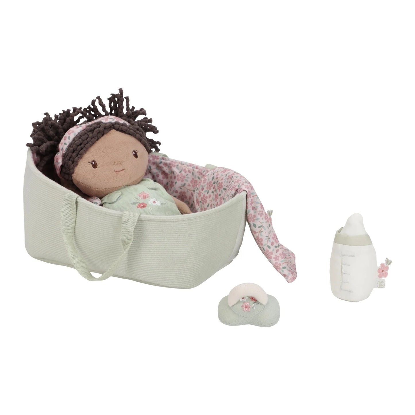 Baby doll with accessories including a bottle and shoes, lying in a cradle on a white background.
