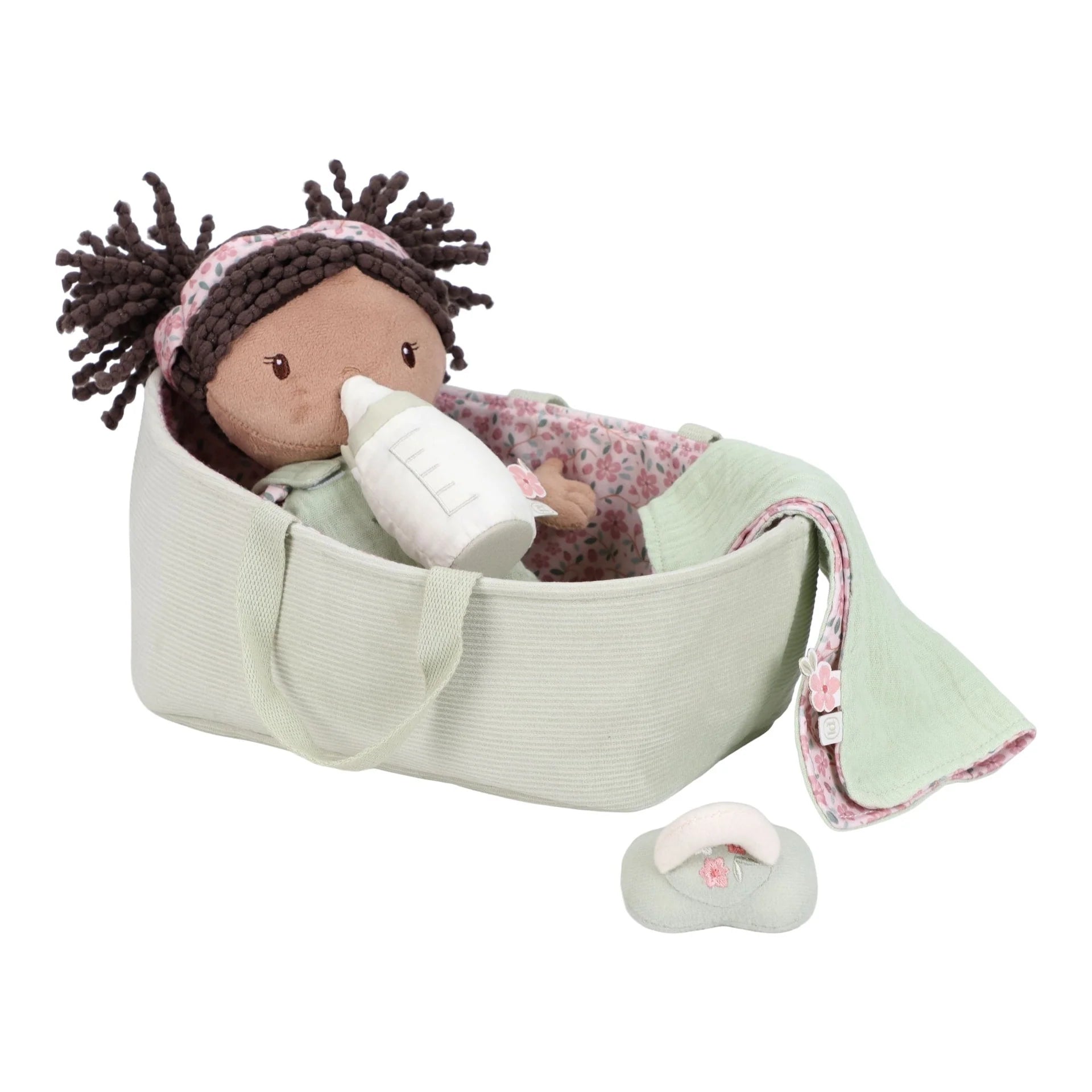 Baby doll with bottle and blanket in a green basket on a white background