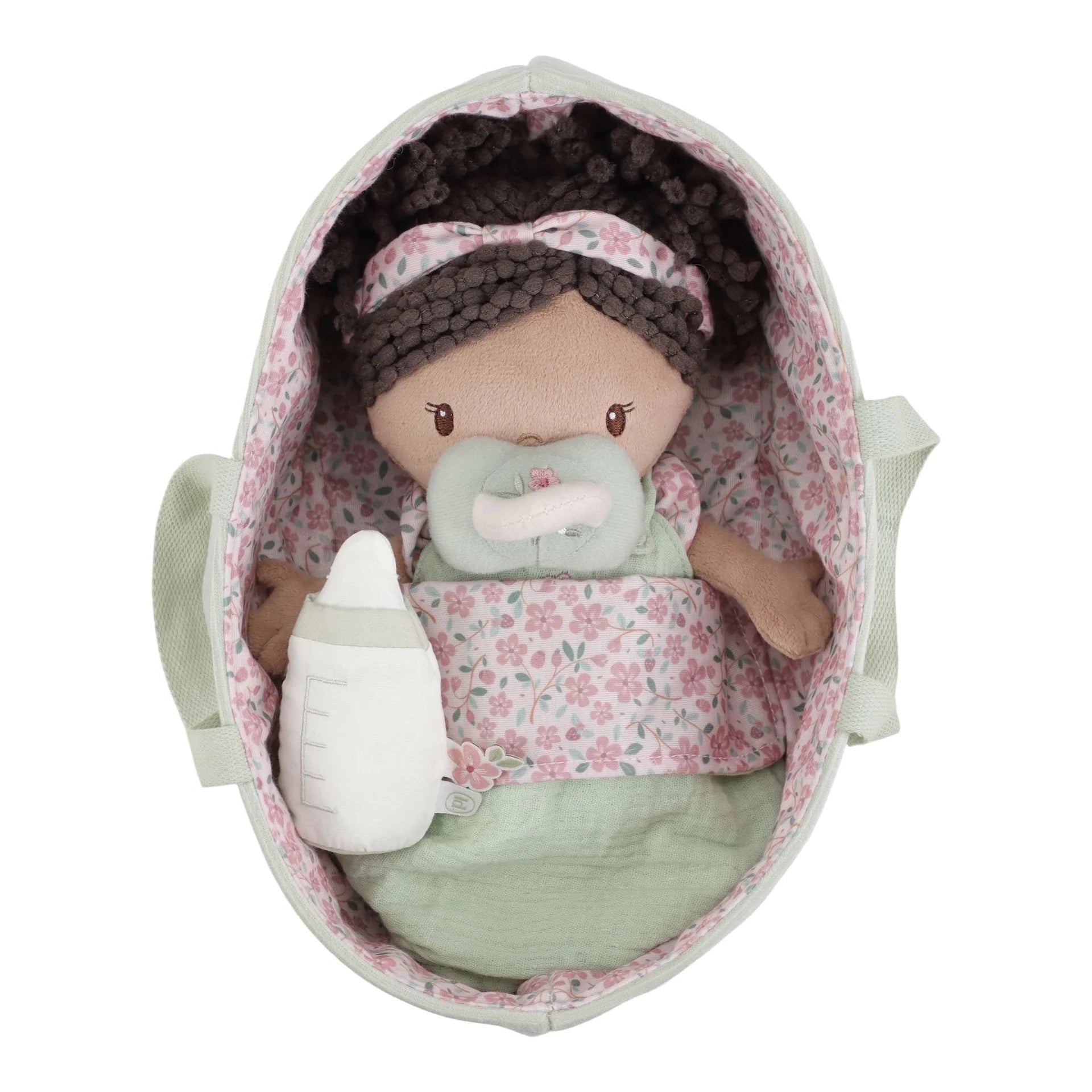 Toy baby doll with pacifier and floral blanket inside a floral-patterned crib