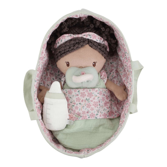 Toy baby doll with pacifier and floral blanket inside a floral-patterned crib