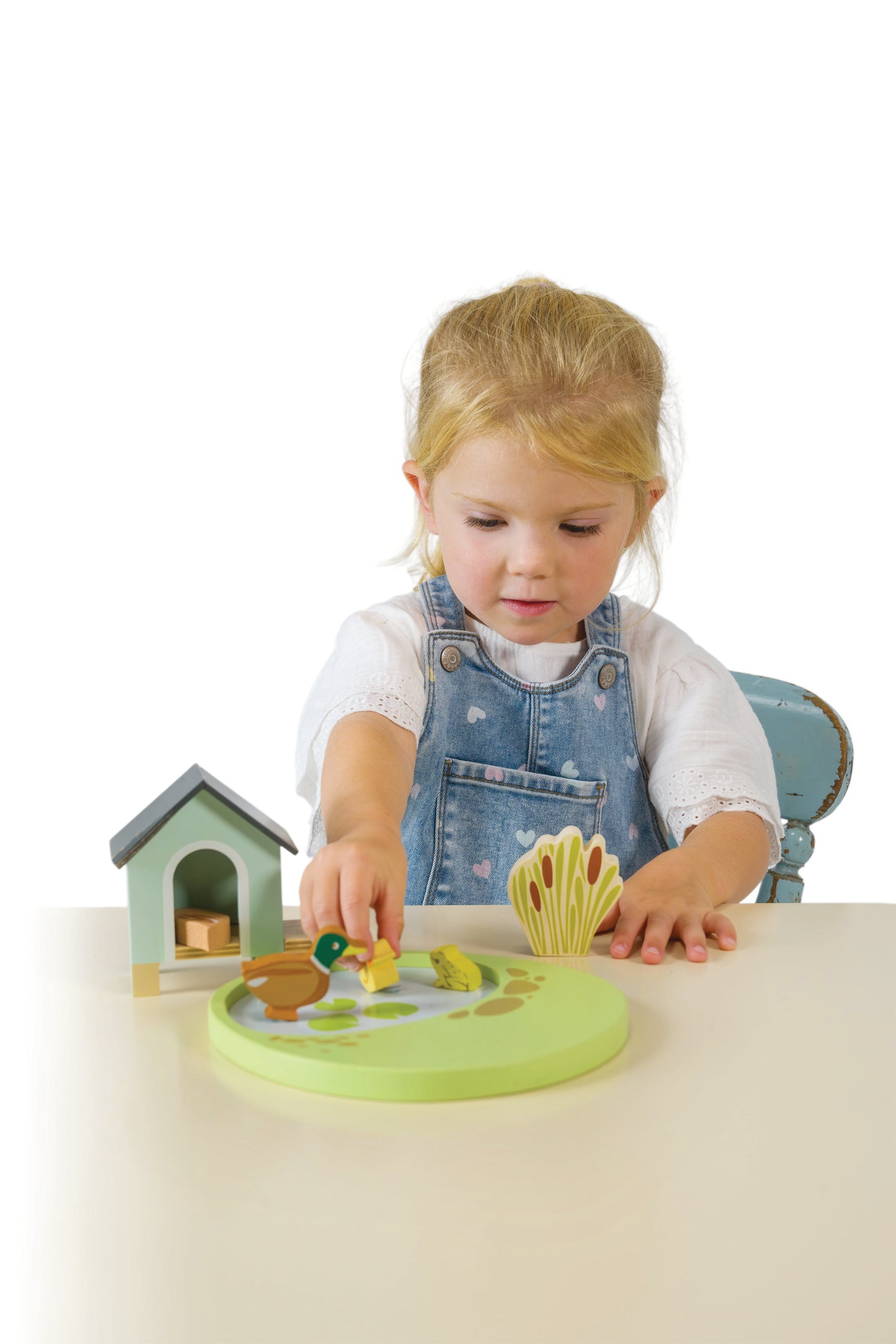 Child playing with a wooden toy at a table