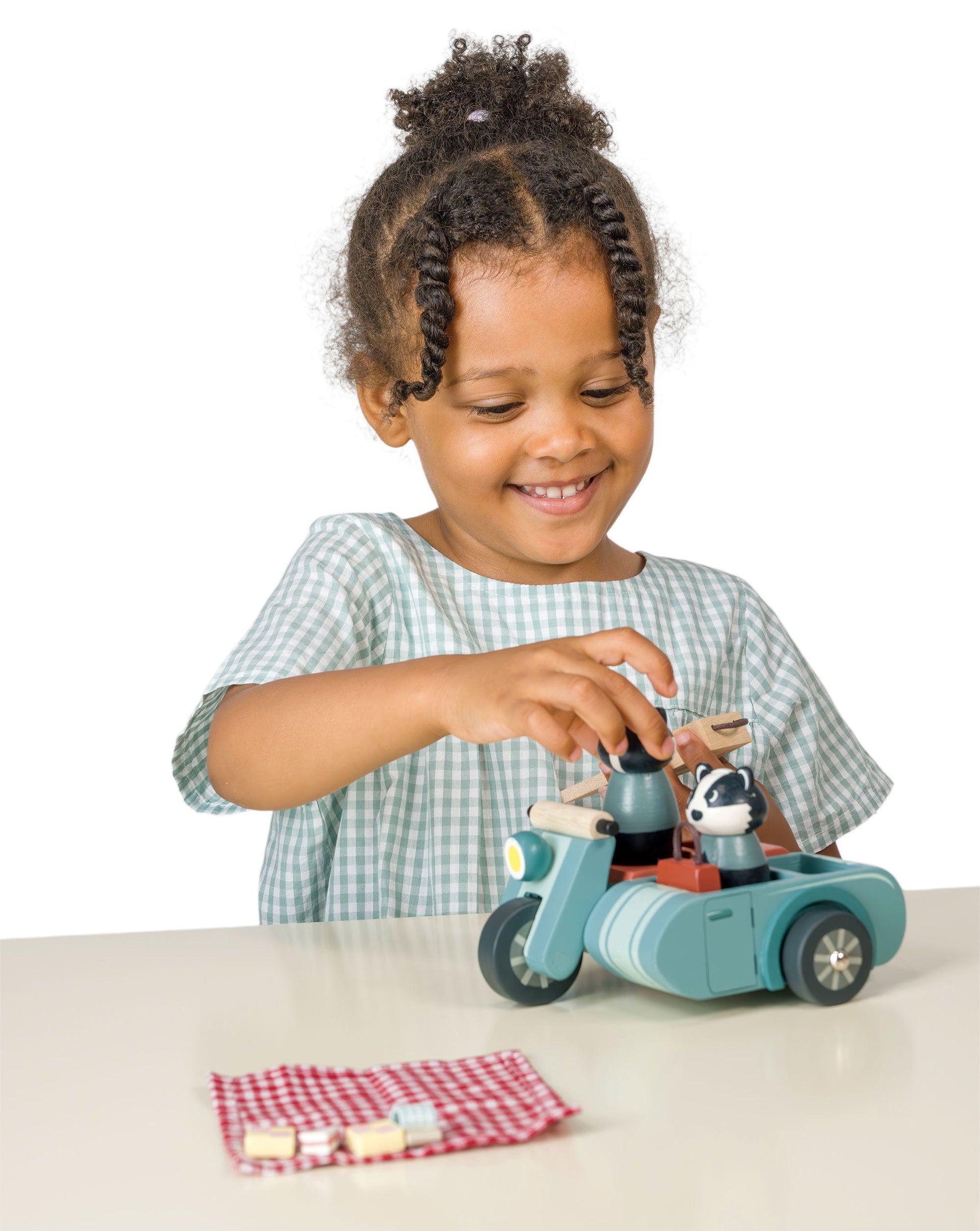 Child playing with a toy vehicle on a white background