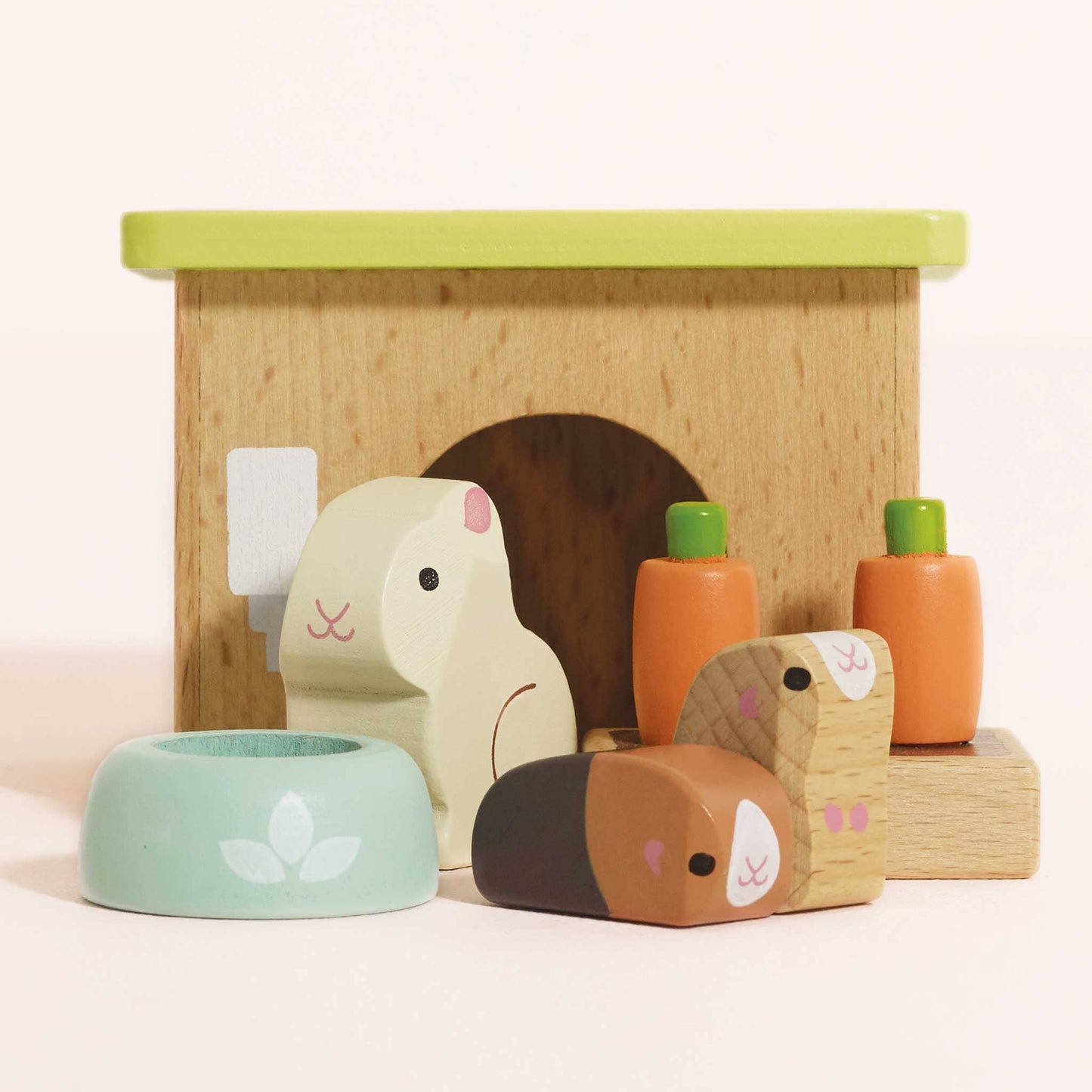 Wooden toy set with animal figures and a small house on a light pink background