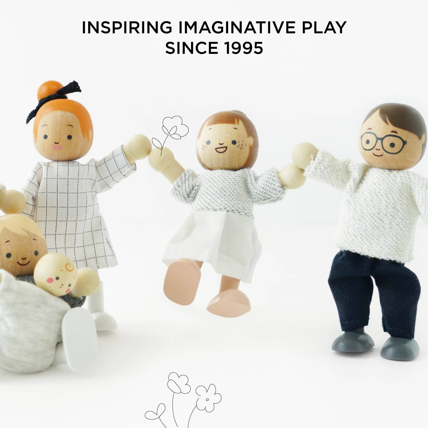 Wooden dolls holding hands with text 'Inspiring Imaginative Play Since 1995' on a white background