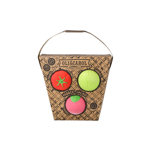 Packaging of Oli & Carol toy balls with tomato, lime, and apple designs on a white background.